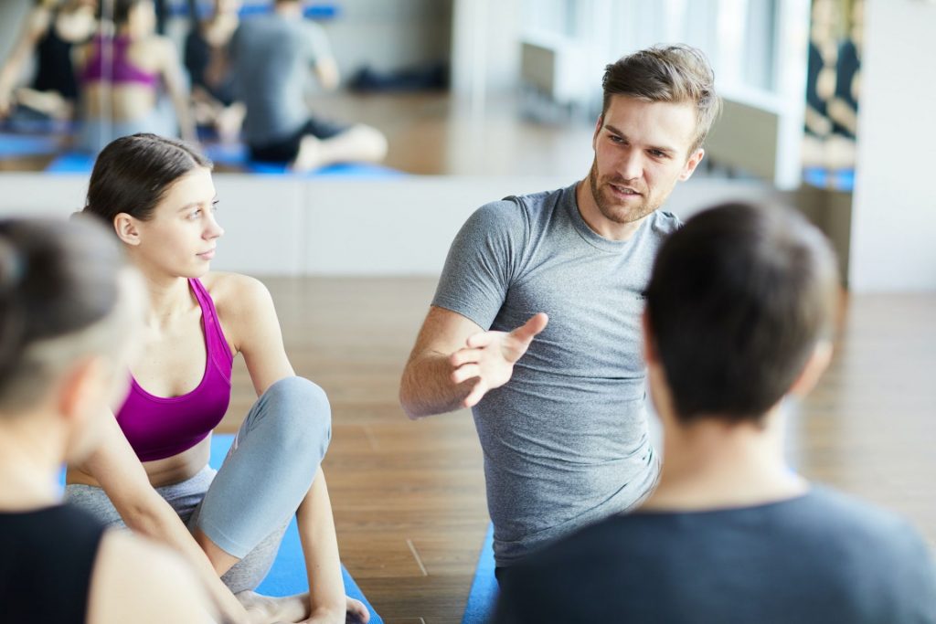 Sporty guy sharing ideas at yoga class